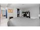 Bedroom with wood frame bed and gray bedding with an open closet and entry to workout room at 8544 S Upham Way, Littleton, CO 80128