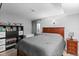 Comfortable bedroom features a wood bed frame, gray comforter, shelving and a window at 8544 S Upham Way, Littleton, CO 80128