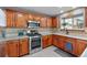 Charming kitchen with wooden cabinets, stainless steel appliances, and tiled backsplash at 8544 S Upham Way, Littleton, CO 80128