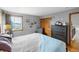 Spacious bedroom features light gray walls, a gray dresser, closet and large window for natural light at 8544 S Upham Way, Littleton, CO 80128