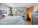 Comfortable bedroom features light gray walls, wood floors, closet, and windows letting in natural light at 8544 S Upham Way, Littleton, CO 80128