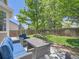 Comfortable backyard patio with woven seating, blue cushions, a table, and shade from mature trees at 12653 Jersey E Cir, Thornton, CO 80602