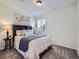 Well-lit bedroom featuring a plush bed, side table, and large window offering natural light at 12653 Jersey E Cir, Thornton, CO 80602