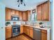 Well-lit kitchen featuring stainless steel appliances, warm wood cabinetry, and ample counter space at 12653 Jersey E Cir, Thornton, CO 80602