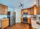 Modern kitchen equipped with stainless steel appliances, wood cabinets, and a door leading to outside at 12653 Jersey E Cir, Thornton, CO 80602