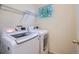 Functional laundry room featuring a modern washer and dryer, a wire shelf, and a window for natural light at 12653 Jersey E Cir, Thornton, CO 80602