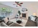Comfortable living room with a fireplace, ceiling fan, and neutral color scheme for a relaxing atmosphere at 12653 Jersey E Cir, Thornton, CO 80602