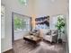 Bright living room featuring vaulted ceilings, large windows, stylish decor, and plush carpeting at 12653 Jersey E Cir, Thornton, CO 80602