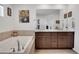 Primary bathroom featuring double sinks, granite countertops, and a soaking tub for relaxation at 87 Green Fee Cir, Castle Pines, CO 80108