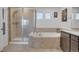 Bright bathroom featuring a tiled shower and a separate tiled tub underneath windows at 87 Green Fee Cir, Castle Pines, CO 80108