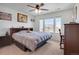 Bedroom with neutral carpet, ceiling fan, and large window letting in natural light at 87 Green Fee Cir, Castle Pines, CO 80108