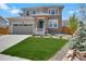 Beautiful two-story home featuring a well-maintained lawn and a charming stone-accented entryway at 87 Green Fee Cir, Castle Pines, CO 80108