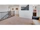 Open hallway featuring neutral walls and carpet, enhanced by a staircase and a decorative painting at 87 Green Fee Cir, Castle Pines, CO 80108