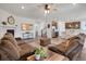 Open-concept living room flows into the kitchen, featuring hardwood floors, comfortable seating, and a fireplace at 87 Green Fee Cir, Castle Pines, CO 80108