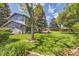Secluded backyard featuring a lush green lawn, mature trees, and a cozy patio area at 6338 S Oneida Ct, Centennial, CO 80111