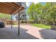 Expansive backyard featuring a stone patio, mature trees, and a manicured lawn at 6338 S Oneida Ct, Centennial, CO 80111