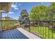 Balcony view overlooking a beautifully landscaped backyard with mature trees and a wood fence at 6338 S Oneida Ct, Centennial, CO 80111