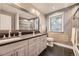 Bathroom with double vanity sinks, grey tile, and a glass-enclosed shower at 6338 S Oneida Ct, Centennial, CO 80111