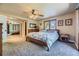 Comfortable bedroom features a ceiling fan, mirrored closet doors, and neutral carpeting at 6338 S Oneida Ct, Centennial, CO 80111