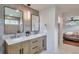 Bright bathroom featuring a double vanity, modern lighting, and access to the main bedroom at 2598 Teller St, Lakewood, CO 80214