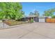 Charming single story home with a large concrete driveway and a well-manicured lawn at 2598 Teller St, Lakewood, CO 80214