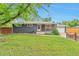 Single-story home features a large front yard, painted brick, a covered porch, and attached garage at 2598 Teller St, Lakewood, CO 80214