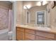 Bathroom with a double sink vanity, a shower with a tile surround, and a large mirror at 29433 Firethorne Ct, Evergreen, CO 80439