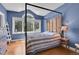 Charming bedroom with a four-poster bed, hardwood floors and a large window with an arch at 29433 Firethorne Ct, Evergreen, CO 80439