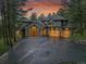 Beautiful twilight shot of a two-story home with stone accents and a three-car garage at 29433 Firethorne Ct, Evergreen, CO 80439