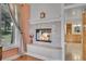 Fireplace with decorative tile surround, wooden mantle, and view into the main bathroom at 29433 Firethorne Ct, Evergreen, CO 80439