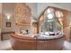 Inviting living room features a stone fireplace, soaring ceilings, and a wall of windows with access to outdoor deck at 29433 Firethorne Ct, Evergreen, CO 80439