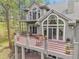 Stunning rear exterior view featuring a spacious deck with decorative flower pots and abundant seating areas at 29433 Firethorne Ct, Evergreen, CO 80439