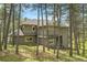 View of the house's rear exterior framed by trees and with lush greenery at 29433 Firethorne Ct, Evergreen, CO 80439