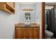 Bathroom with wooden cabinets, vessel sink, and framed mirror at 4465 E 121St Pl, Thornton, CO 80241