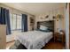 Bedroom featuring headboard with mounted reading lamps, dark wood floors and ample natural light at 4465 E 121St Pl, Thornton, CO 80241