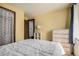 Cozy bedroom with neutral-colored walls, a dresser, a nightstand with a lamp, and a window with natural light at 4465 E 121St Pl, Thornton, CO 80241