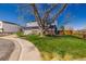 Well-kept front lawn featuring a mature tree and a charming blue home with an attached two-car garage at 4465 E 121St Pl, Thornton, CO 80241