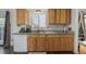 Kitchen featuring wood cabinets and a white dishwasher along with granite countertops at 4465 E 121St Pl, Thornton, CO 80241