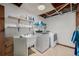 Functional laundry room features a utility sink, washer, dryer and ample shelving for storage solutions at 4465 E 121St Pl, Thornton, CO 80241