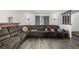 Comfortable living room featuring a large sectional sofa, wood-look flooring, and natural light at 4465 E 121St Pl, Thornton, CO 80241