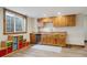 Basement kitchenette featuring custom wood cabinets, a sink, a dishwasher, and natural light at 13561 W 87Th Dr, Arvada, CO 80005