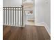 A staircase with light wood flooring and a white railing with natural light from the window at 13561 W 87Th Dr, Arvada, CO 80005