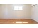 The bedroom features stylish wood-paneled walls, a large window, and beautiful wood floors at 1675 N Wabash St, Denver, CO 80220