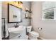 Stylish half bathroom featuring a vanity, decorative shelves, and modern fixtures at 24714 E Quarto Pl, Aurora, CO 80016
