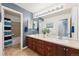Well-lit bathroom featuring a double sink vanity with a shower and tub in the background at 24714 E Quarto Pl, Aurora, CO 80016