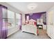 Bright bedroom with a purple accent wall, plush carpet, and vanity area at 24714 E Quarto Pl, Aurora, CO 80016