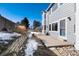 Home's backyard with patio, retaining wall, and snowy ground at 5294 S Espana St, Centennial, CO 80015