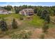 Aerial view of the property with a large backyard, deck, mature trees, and play equipment at 5861 E Valley Hi Dr, Parker, CO 80138