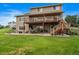 Back of house with multilevel deck, patio, landscaped yard, and outdoor seating areas at 5861 E Valley Hi Dr, Parker, CO 80138