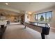 Basement area features a pool table, bar, carpet, and large window at 5861 E Valley Hi Dr, Parker, CO 80138
